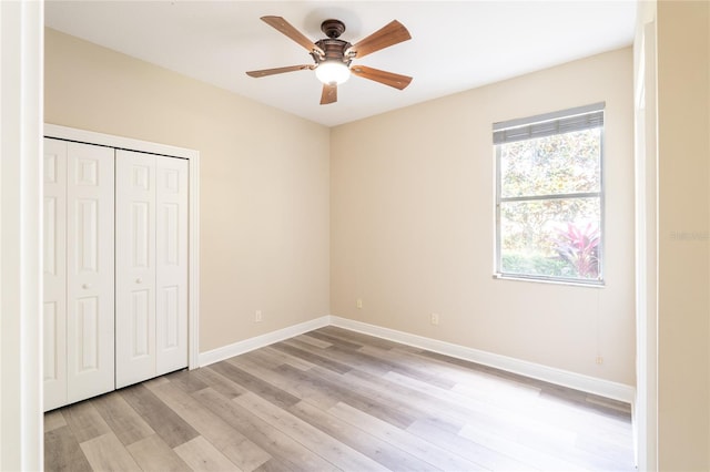 unfurnished bedroom featuring light hardwood / wood-style floors, a closet, and ceiling fan