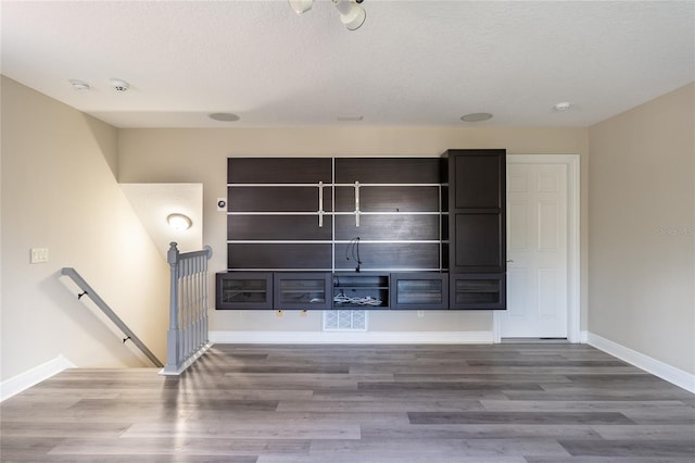 unfurnished living room with wood-type flooring and a textured ceiling