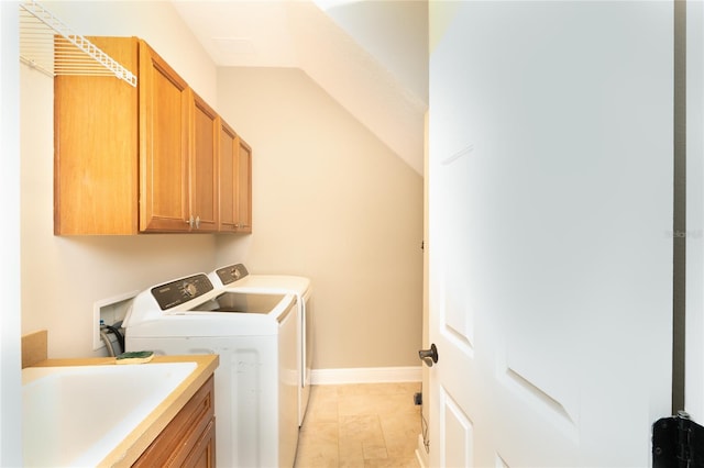 clothes washing area with independent washer and dryer, sink, and cabinets