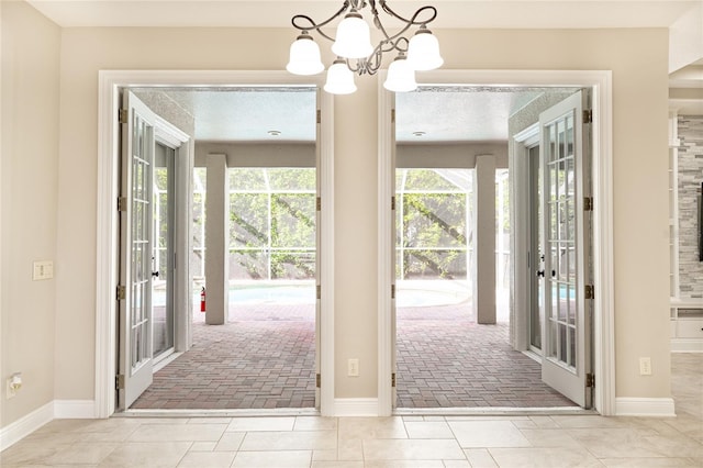 entryway with a notable chandelier and light tile patterned floors