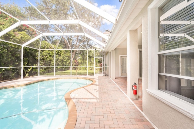 view of pool with a patio and a lanai