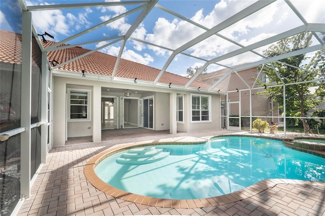 view of swimming pool featuring an in ground hot tub, a patio, and glass enclosure