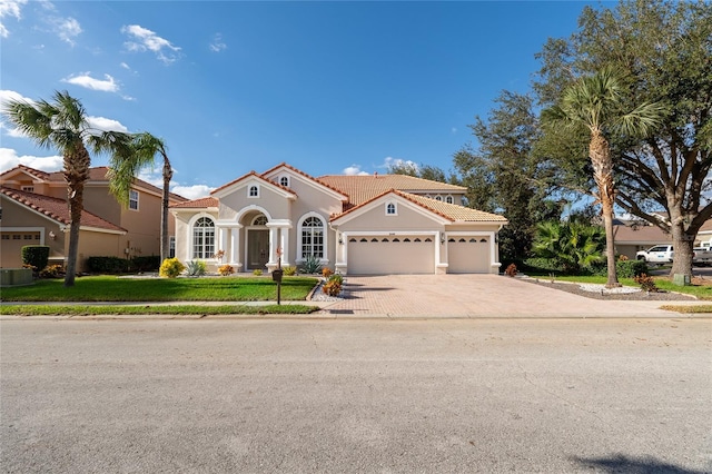 mediterranean / spanish-style home with a garage and a front yard