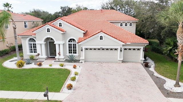 mediterranean / spanish home featuring a garage and a front yard