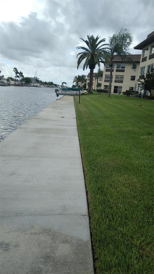 view of dock featuring a lawn and a water view