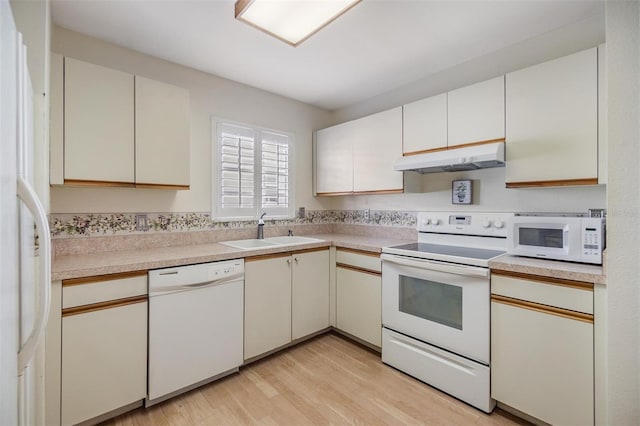 kitchen with white cabinetry, light wood-type flooring, sink, and white appliances