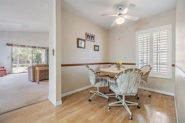 dining room with light hardwood / wood-style flooring, lofted ceiling, and ceiling fan