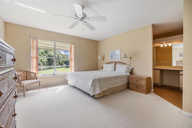 bedroom featuring a textured ceiling, carpet flooring, and ceiling fan