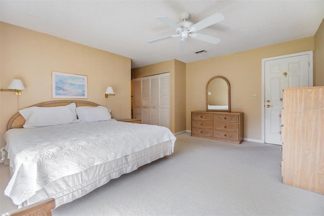 carpeted bedroom featuring ceiling fan and a closet