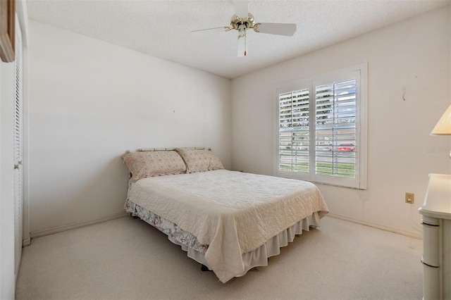 carpeted bedroom with a textured ceiling, ceiling fan, and a closet