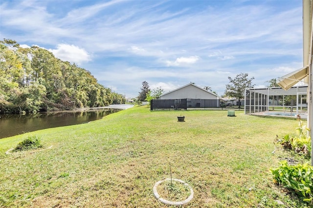 view of yard with a swimming pool, glass enclosure, and a water view