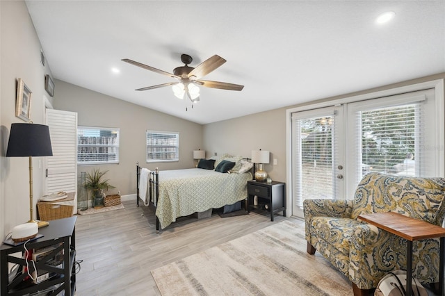 bedroom with light hardwood / wood-style floors, ceiling fan, access to exterior, vaulted ceiling, and french doors