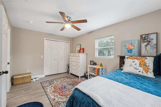 bedroom featuring ceiling fan, a closet, and light wood-type flooring