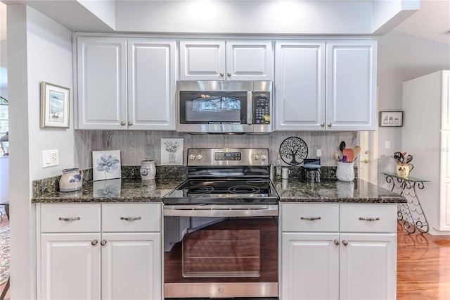 kitchen featuring dark stone countertops, tasteful backsplash, white cabinetry, and stainless steel appliances