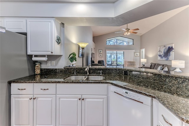 kitchen with white cabinetry, white dishwasher, sink, vaulted ceiling, and dark stone countertops