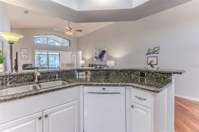 kitchen with white dishwasher, sink, light hardwood / wood-style floors, white cabinets, and lofted ceiling