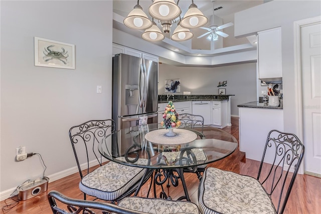 dining room with wood-type flooring, ceiling fan, and sink