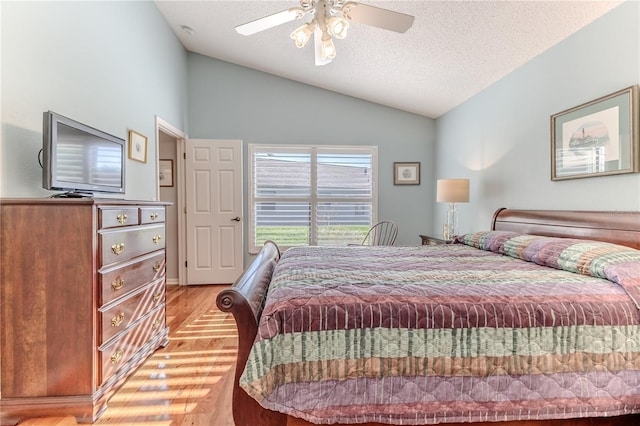 bedroom with light wood-type flooring, lofted ceiling, a textured ceiling, and ceiling fan