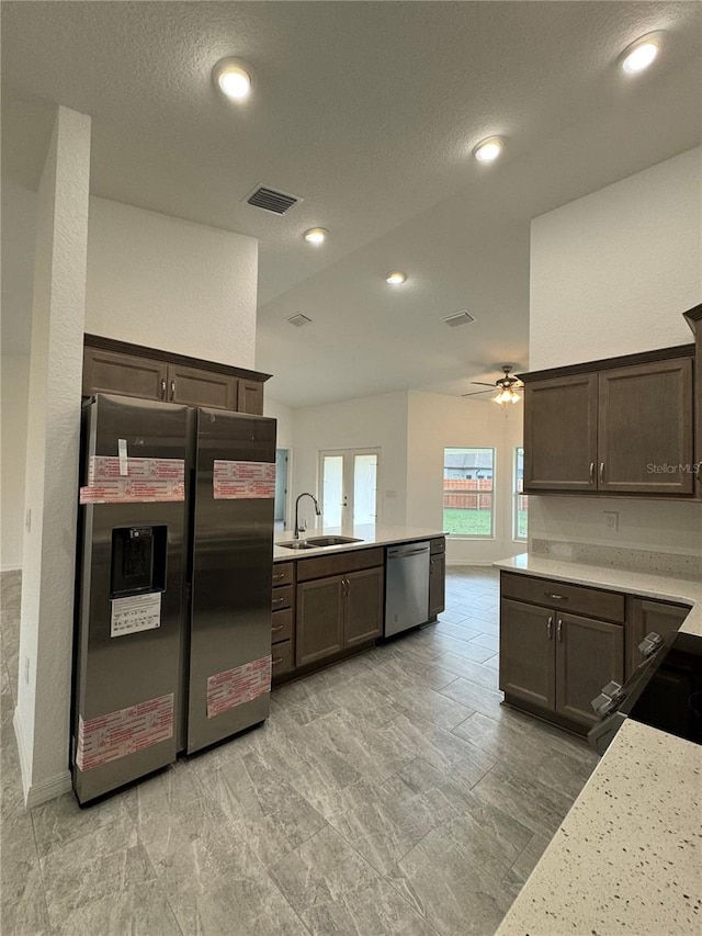 kitchen with dark brown cabinets, stainless steel appliances, ceiling fan, and sink