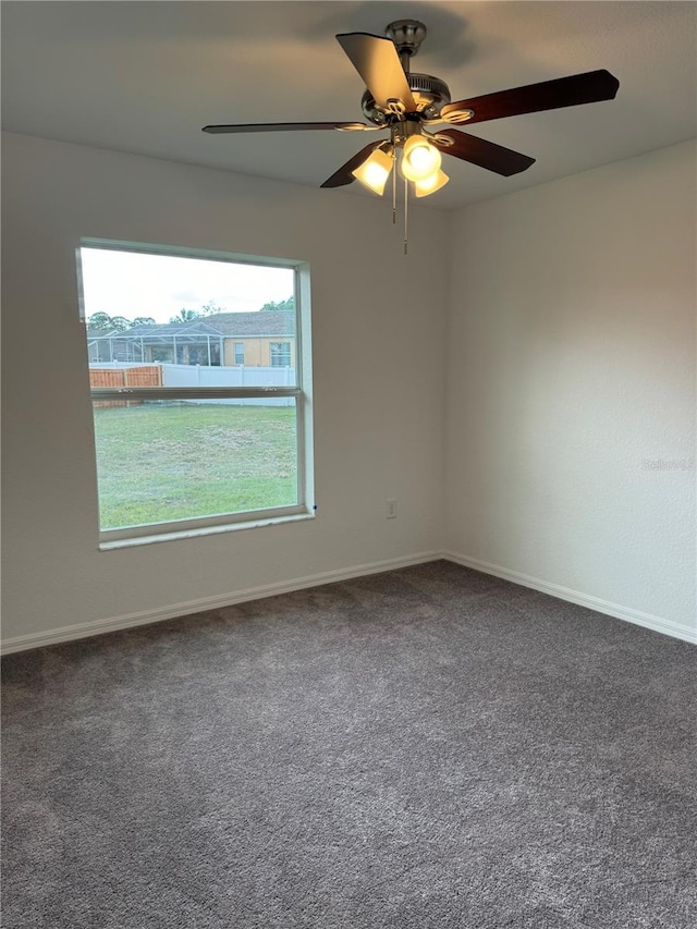 carpeted spare room featuring ceiling fan