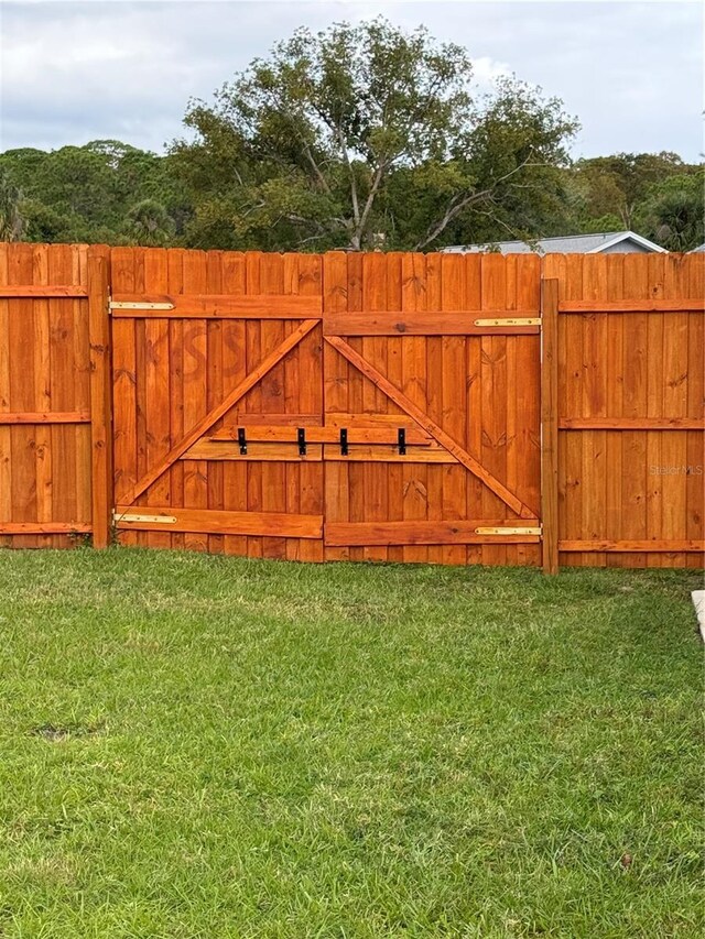 view of gate featuring a lawn