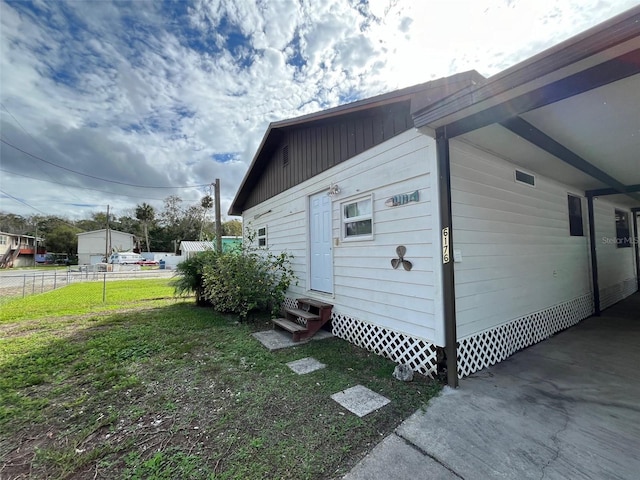 view of property exterior with entry steps and a carport