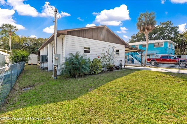 view of side of home featuring a carport, driveway, and entry steps