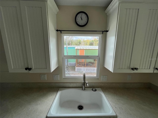 kitchen featuring a sink and white cabinetry