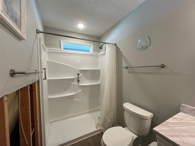 full bath with a textured ceiling, toilet, vanity, a shower with shower curtain, and wood finished floors