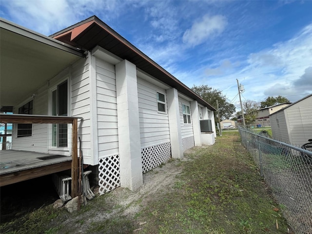 view of side of home with fence and a wooden deck