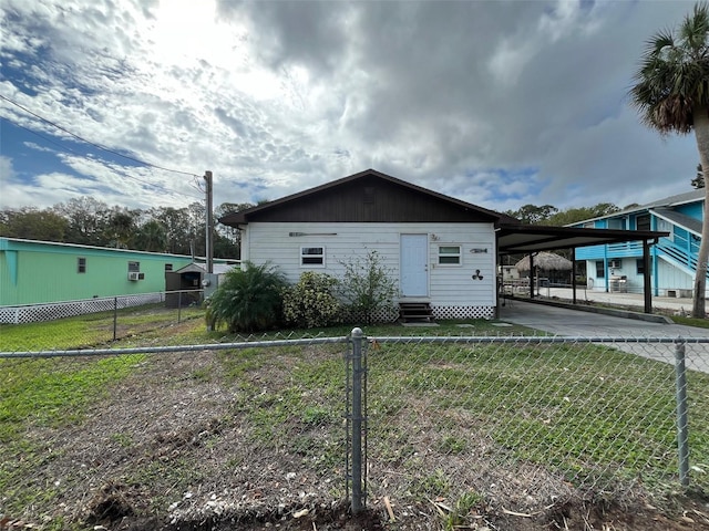 view of front facade featuring entry steps, driveway, and a carport