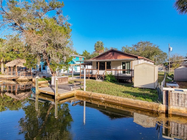 dock area with a water view and a yard