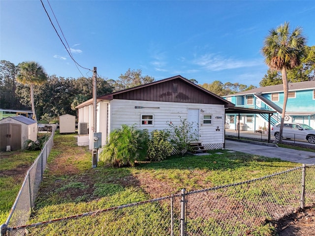 view of side of home featuring entry steps, a carport, a shed, an outbuilding, and driveway