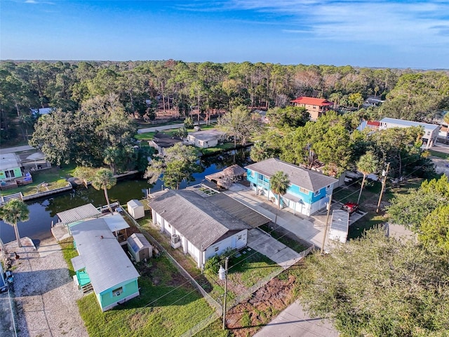 view from above of property with a nearby body of water and a forest