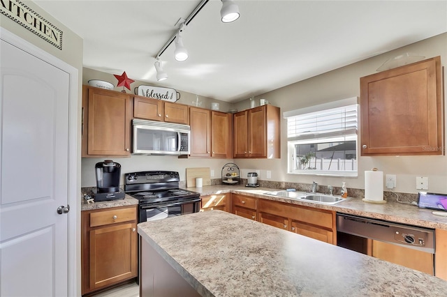 kitchen featuring sink, rail lighting, and appliances with stainless steel finishes