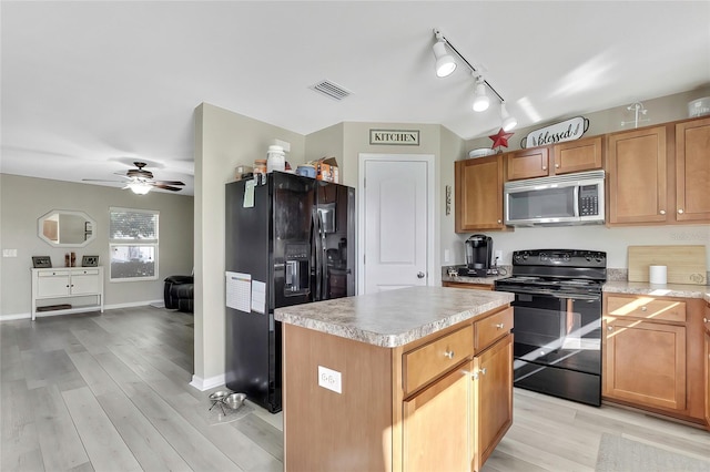 kitchen featuring black appliances, ceiling fan, a center island, and light wood-type flooring