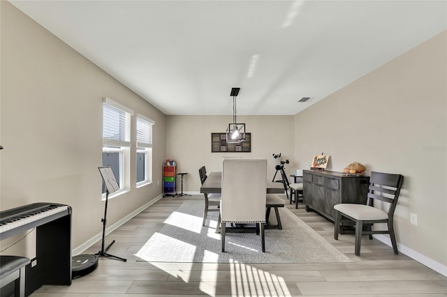 dining space featuring heating unit and light wood-type flooring