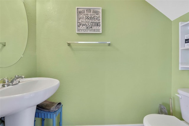 bathroom featuring sink, vaulted ceiling, and toilet