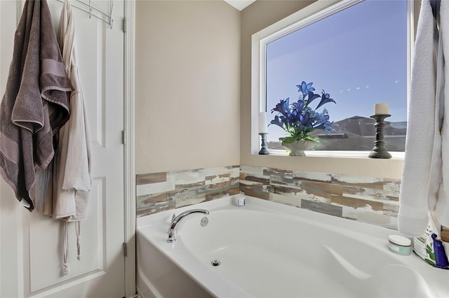 bathroom with a tub to relax in and a wealth of natural light