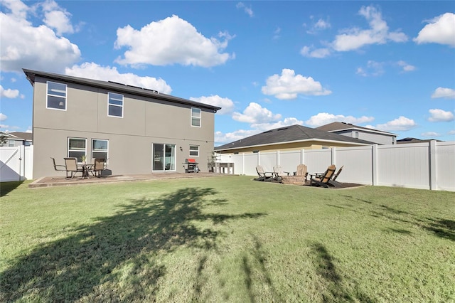 rear view of property with a patio, a fire pit, and a lawn