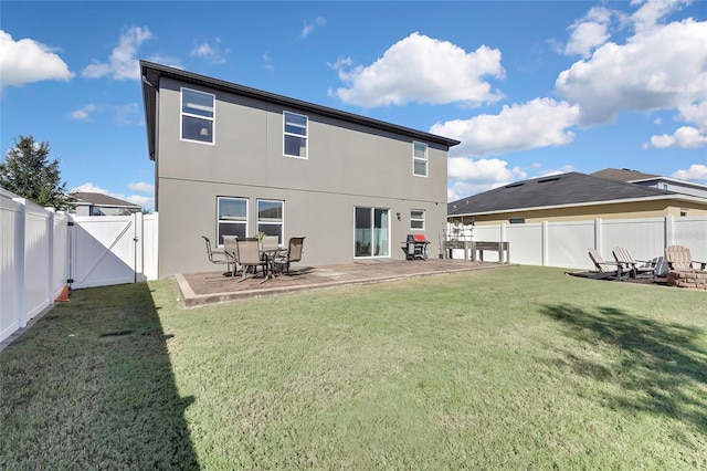 rear view of house featuring a yard and a patio area