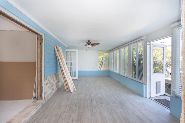 unfurnished sunroom featuring ceiling fan