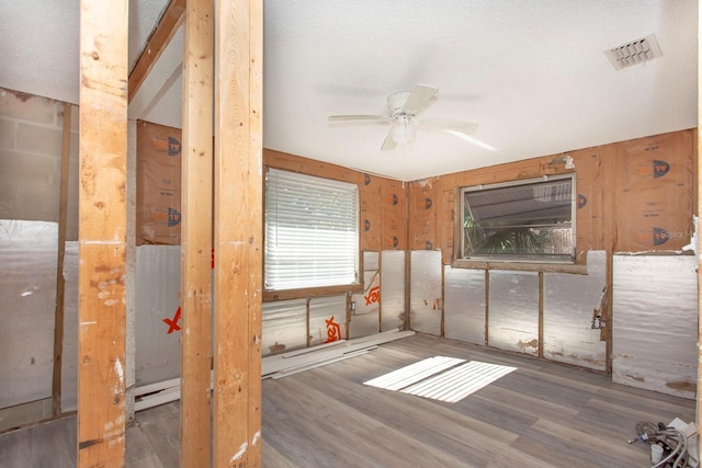 unfurnished room with a textured ceiling, ceiling fan, and dark hardwood / wood-style floors