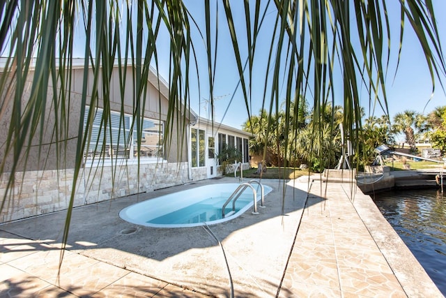 view of swimming pool with a water view and a patio