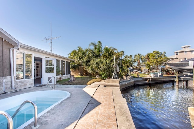 view of pool with a sunroom, a water view, and a patio