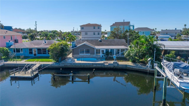 rear view of property featuring a water view, a patio area, and a swimming pool