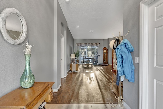 hallway featuring hardwood / wood-style floors and a textured ceiling