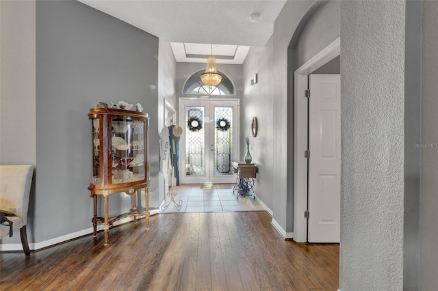 entrance foyer with french doors, hardwood / wood-style floors, and a textured ceiling