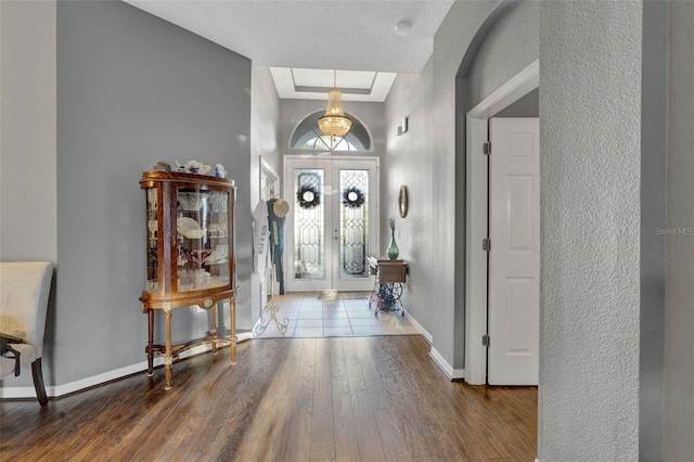 2533 Wood Pointe Dr, Holiday, FL 34691 - foyer with wood finished floors, french doors, baseboards, and a textured wall