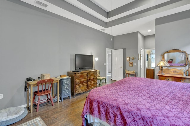 bedroom with a high ceiling and dark hardwood / wood-style flooring